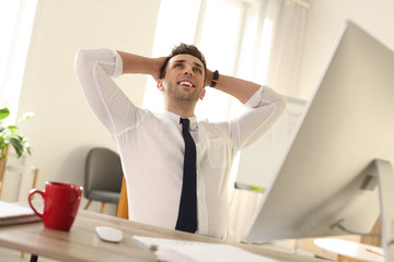 Fototapeta premium Young businessman relaxing at table in office during break