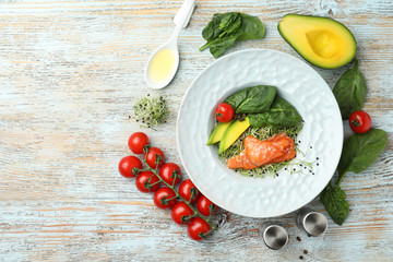 Delicious salmon with spinach served on light wooden table, flat lay