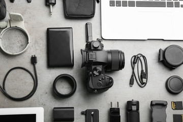 Flat lay composition with camera and video production equipment on light grey stone background