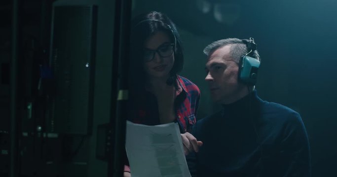 Director holding the script and discussing with a crew member