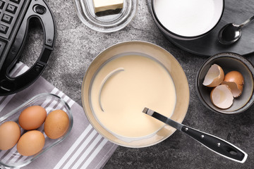 Flat lay composition with ingredients for cooking Belgian waffles on grey table