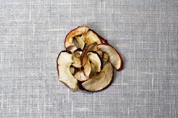 Dried Apple chips on a gray textile background. Organic natural food. Top view. Flat lay. Copy space.