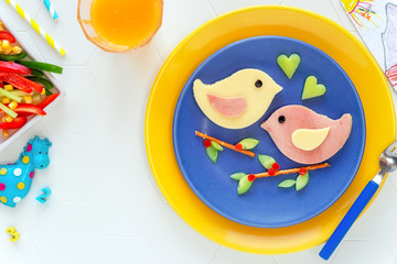 Fun food for kids - cute bird shaped sandwiches or ham and cheese toasts served with vegetables and...