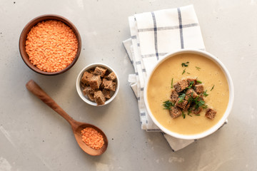 Tomato soup in a black bowl on grey stone background. Top view. Copy space.