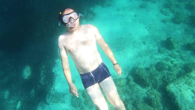 Snorkeling guy showing the fuck you sign underwater in the sea