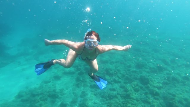 Underwater view of girl in bikini snorkeling in crystal clear sea water