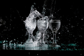glasses with water with splashes on a black background