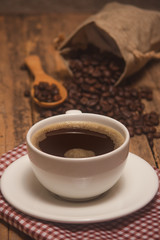 Coffee cups and coffee beans roasted on a wooden table Divide space for text