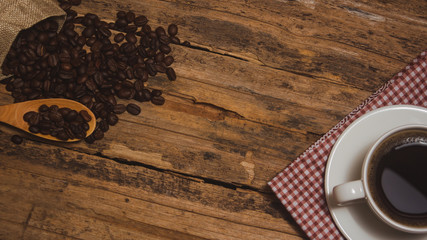 Coffee cups and coffee beans roasted on a wooden table Divide space for text