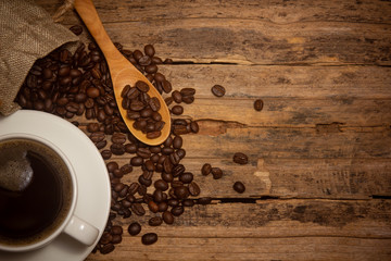 Coffee cups and coffee beans roasted on a wooden table Divide space for text