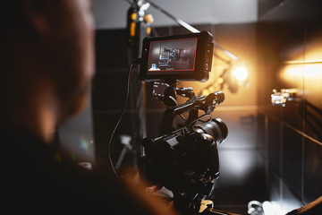 Video production backstage. Behind the scenes of creating video content, a professional team of cameramen with a director filming commercial ads. Video content creation, video creation industry. Low - obrazy, fototapety, plakaty