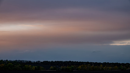 Rainy sky and clouds in the evening in the field. Fall season.