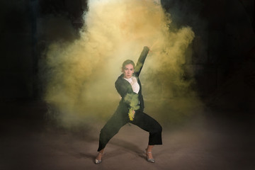 Fototapeta na wymiar Pasadoble, latin solo dance and contemporary dance - Young beautiful female dancing into smoke cloud
