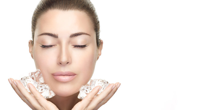 Beauty Skin care Treatments. Spa Woman with healthy clean skin aplying ice cubes on face.