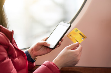 Tourist holding a credit card and using smartphone