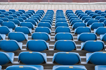 Fototapeta premium Seats in the stadium are in the background. auditorium-stands. Rows of chairs in an open-air stadium. Spectator seats.