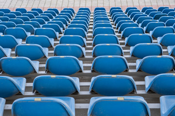 Seats in the stadium are in the background. auditorium-stands. Rows of chairs in an open-air stadium. Spectator seats.