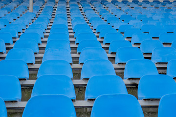 Seats in the stadium are in the background. auditorium-stands. Rows of chairs in an open-air stadium. Spectator seats.