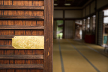 Photograph of a traditional Japanese room with a wooden door in the foreground