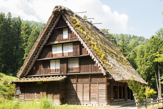 Photograph of an old Japanese house made of wood with earth roof