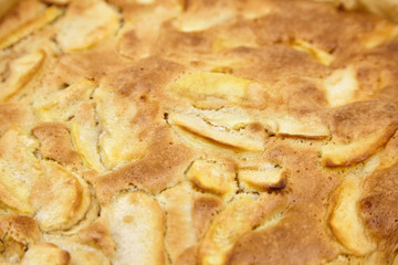 Apple pie, dessert from stewed fruits, closeup, texture, background. Charlotte, homemade baking