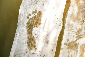 Wet footprint on wooden bridge. Summer rustic photo.