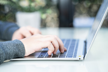 Woman working at home office using laptop searching web, browsing information