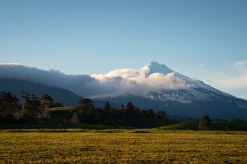 Mt Taranaki at Sunrise with clouds moving over the mountain