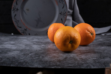 Tropical oranges on a dark rustic space.