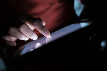 young man use digital tablet at night, close up 