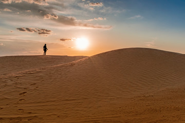 Fototapeta na wymiar sand dunes of the Sahara desert lit by the light of the setting sun of the sun,