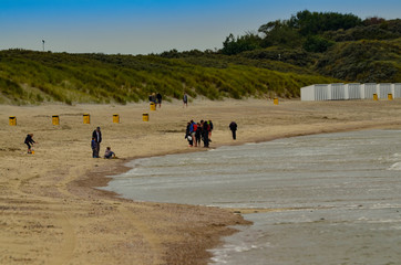 Fototapeta na wymiar Oosterschelde, the Netherlands, August 2019. The north sea coast: large beaches as far as the eye can see, very few people walking along the shore.