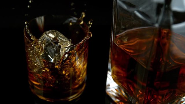 Super Slow Motion Shot of Ice Drop into Glass with Whiskey at 1000fps with Camera Movement.