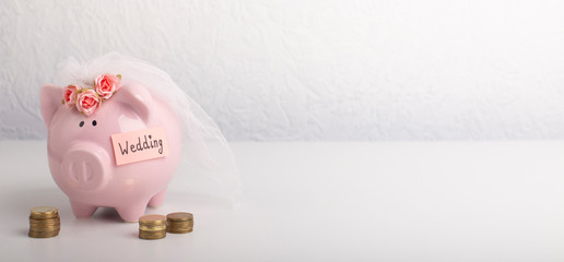 Piggy bank with wedding veil on gray background