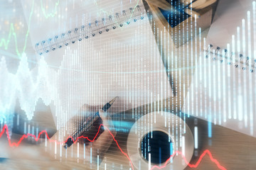 Multi exposure of woman's hands making notes with forex graph hologram. Concept of technical analysis.