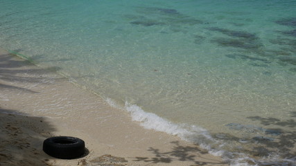 washed up tyre on Long Bay Beach at Koh lipe Island, Thailand