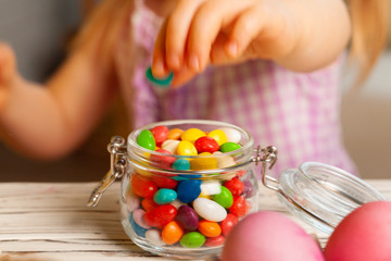 Little girl eating colorful Easter candies close up