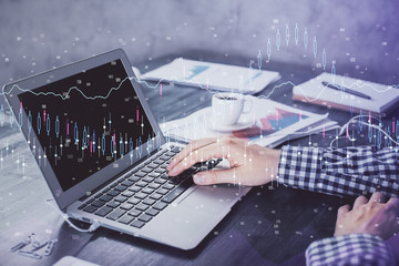 Double exposure of forex chart with man working on computer on background. Concept of market...