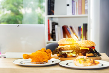  Appetizing lunch, two large pork hamburgers, pizza, fried chicken thighs in the office at home.