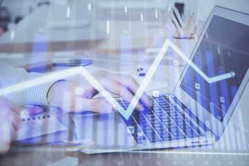 Double exposure of stock market graph with man working on laptop on background. Concept of financial analysis.