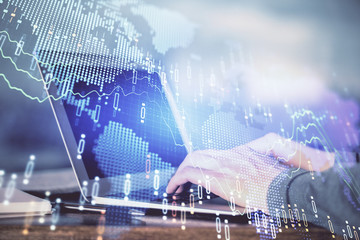 Double exposure of stock market graph with man working on laptop on background. Concept of financial analysis.