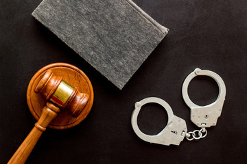 Arrest concept. Handcuffs near judge gavel on black background top-down