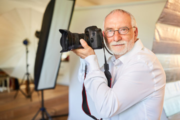 Selbständiger älterer Fotograf in seinem Fotostudio