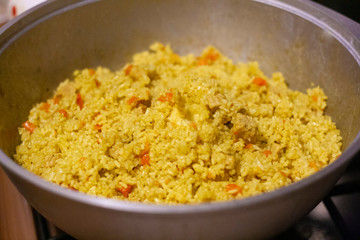 Homemade pilaf cooked in a cauldron on the stove