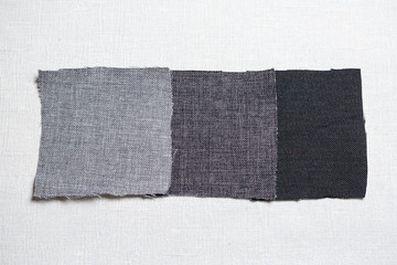 square pieces of multi-colored fabric laid out on a gray background