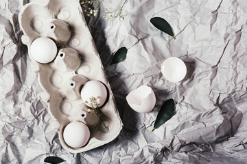Easter eggs in a carton box, top view, spring flowers and freshen up