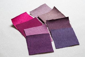 square pieces of multi-colored fabric laid out on a gray background