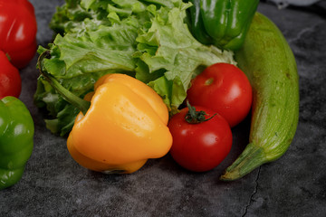 Red tomatoes with lettuce, zucchini and yellow bell pepper.