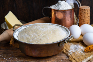 Dough and ingredients for homemade bread, khachapuri or pizza. Dark food background. Close up, horizontal