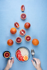Healthy Breakfast for adults and children. Oatmeal porridge with red oranges. Fresh fruit for Breakfast. Beautiful table setting in blue and red tones. Top view, vertical
